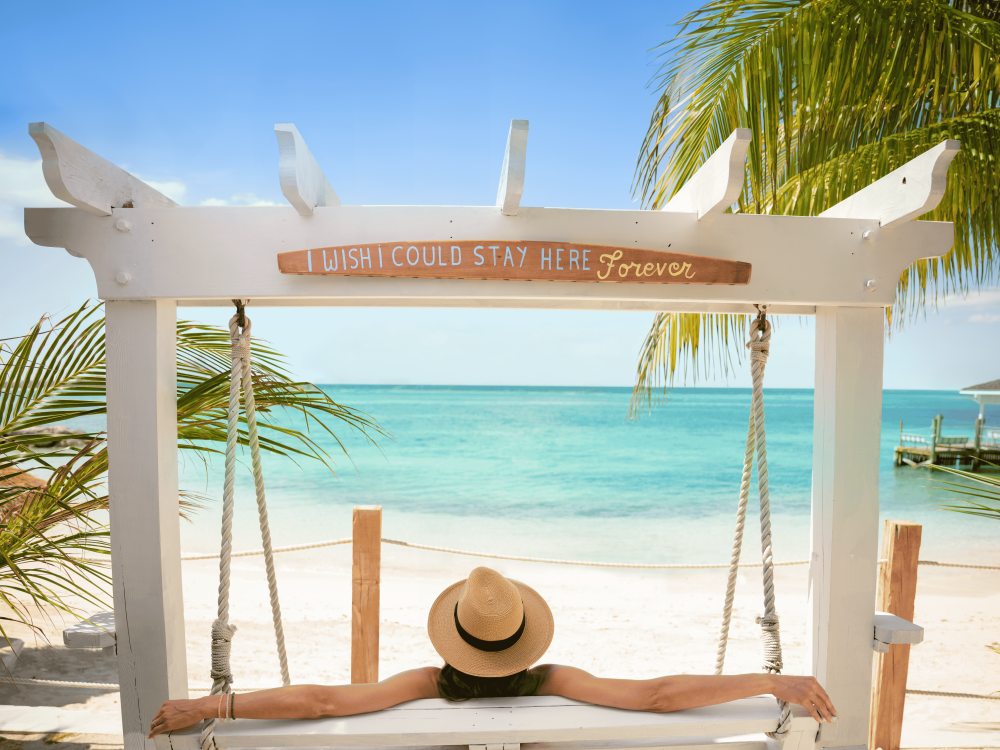 woman on a swinging bench at the beach