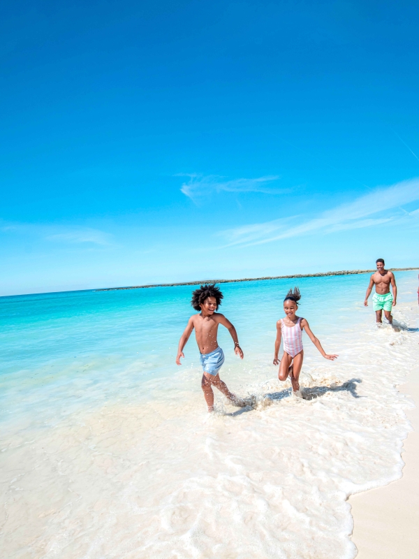 family running along the beach